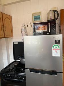 a kitchen with a stove and a refrigerator at Nadine's Enclave in Kisii