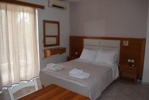 a bedroom with a bed with two towels on it at Lydia Rooms & Studios in Preveza