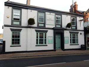 un edificio blanco al lado de una calle en The White Swan, en Market Rasen