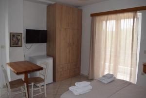 a bedroom with a bed and a table and a desk at Lydia Rooms & Studios in Preveza