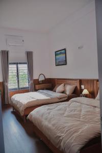 a bedroom with two beds and a window at Mộng Homestay in Huế in Thôn Trường Giang