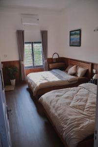 a hotel room with two beds and a window at Mộng Homestay in Huế in Thôn Trường Giang