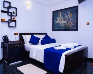 a bedroom with a bed with blue and white sheets at Thenulya Resort in Ella