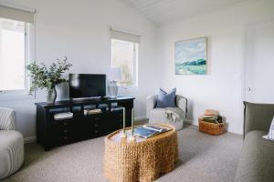 a living room with a tv and a table at Suma Park Estate in Point Lonsdale
