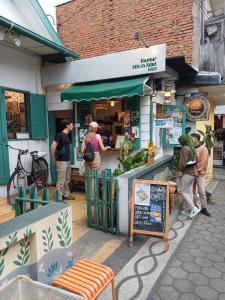 a group of people standing outside of a restaurant at Irma Guest House Syariah in Temenggungan