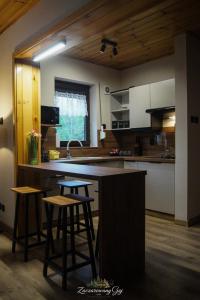 a kitchen with a counter and stools in a room at Zaczarowany Gaj in Gaj Grzmięca