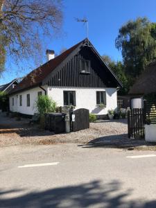 a white house with a black roof at Rum på landet in Klagstorp