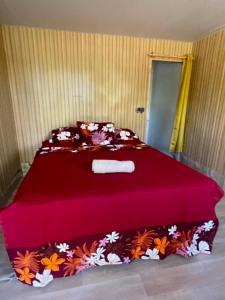 a bedroom with a large red bed with a red blanket at PENSION NATIRENA LODGE Hao in Otepa