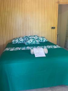 a green bed with a paper on top of it at PENSION NATIRENA LODGE Hao in Otepa