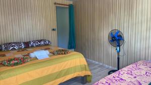 a bedroom with a bed and a fan at PENSION NATIRENA LODGE Hao in Otepa