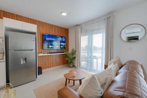 a living room with a couch and a tv at Aura Sosua Ocean Village in Sosúa