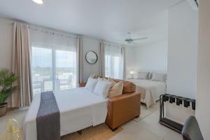 a bedroom with a bed and a bed and a couch at Aura Sosua Ocean Village in Sosúa +25 photos