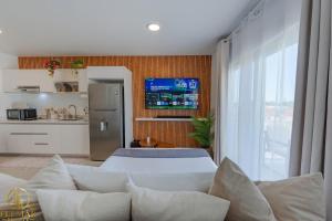a living room with a bed and a tv at Aura Sosua Ocean Village in Sosúa