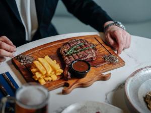 a plate of steak and french fries on a table at Novotel Istanbul Zeytinburnu in Istanbul