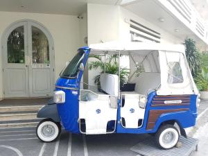 un pequeño carrito de golf azul y blanco estacionado fuera de un edificio en The Clipper House, en Manila