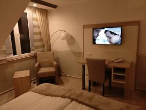 a hotel room with a bed and a tv on the wall at Landhotel Zum Hasen Hein in Hamminkeln