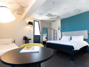 a hotel room with two beds and a table at ibis Marseille Centre Euromed in Marseille +121 photos