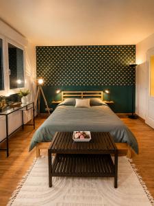 a bedroom with a large bed and a table at Green Balcony Lille Hyper centre in Lille