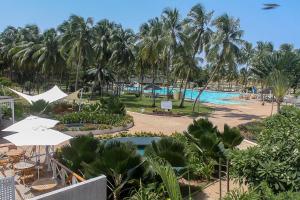 a view of a resort with a pool and palm trees at Hôtel Sarakawa in Lomé