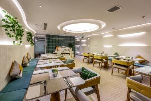 a restaurant with tables and chairs and a large window at IconSphere Hotel in Ho Chi Minh City