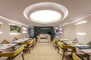 a restaurant with tables and chairs and a large ceiling at IconSphere Hotel in Ho Chi Minh City +44 photos