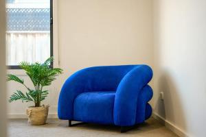 a blue chair in a room with a plant at Seednest Stylish & Perfect for Relaxation in Melton South