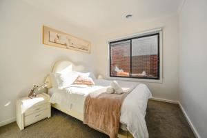 a bedroom with a white bed and a window at Seednest Stylish & Perfect for Relaxation in Melton South +26 photos