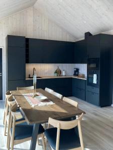 a kitchen with a wooden table and blue cabinets at Panoramic Cabin With Sea View On Randøy in Hjelmeland