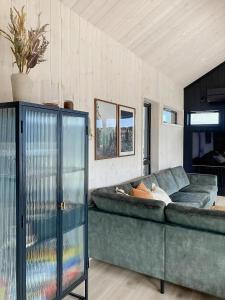 a living room with a green couch in a room at Panoramic Cabin With Sea View On Randøy in Hjelmeland