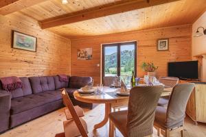 a living room with a purple couch and a table at Kraševec Lodge with Garden & Pool - Happy Rentals in Velike Bloke