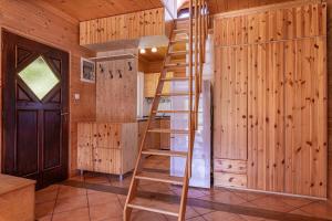 a wooden ladder in a room with a refrigerator at Kraševec Lodge with Garden & Pool - Happy Rentals in Velike Bloke