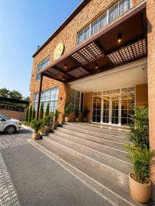 a brick building with stairs in front of it at Hotel Sunshine in Surajpur Jikkla