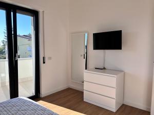 a bedroom with a bed and a television on a dresser at A casa di Chiara in Isca sullo Ionio