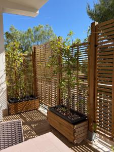a patio with two potted plants on a wooden fence at Dimore Capirro Charming Family House in Trani