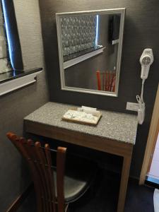 La salle de bains est pourvue d'une coiffeuse avec un miroir et une chaise. dans l'établissement Nice Hotel, à Taipei