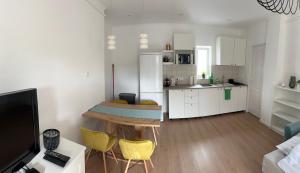 a kitchen and living room with a table and yellow chairs at Vendégház Alsóörs in Alsóörs