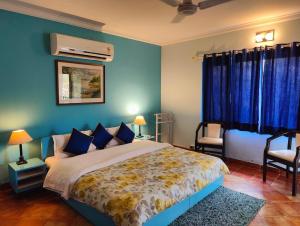 a bedroom with a large bed with blue walls at The Nagri Resort in Pālampur
