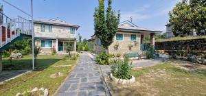 a house with a garden in front of a house at The Nagri Resort in Pālampur