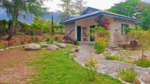 a small house with flowers in front of it at The Nagri Resort in Pālampur