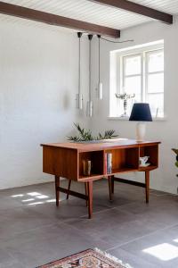 a wooden desk in a room with a window at Protected Nature At Thatched Gem in Gørlev