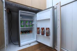 an open refrigerator filled with drinks and soda at Shikali Resort in Pātan