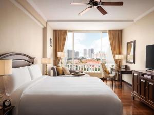 a hotel room with a large bed and a window at Sofitel Phnom Penh Phokeethra in Phnom Penh