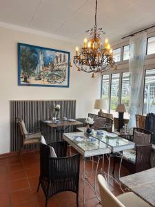 a living room with tables and chairs and a chandelier at Aparthotel Domizil in Borkum