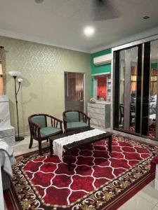 a living room with two chairs and a red rug at Farshada Homestay villa in Kapar