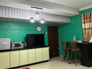 a living room with a television and a counter with chairs at Farshada Homestay villa in Kapar