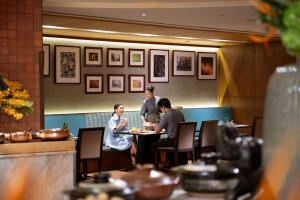 a group of people sitting at a table in a restaurant at Conrad Bangkok in Bangkok