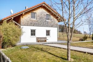a white house with a bench in front of it at Ferienhaus Geyerbad mit Sauna in Meßstetten