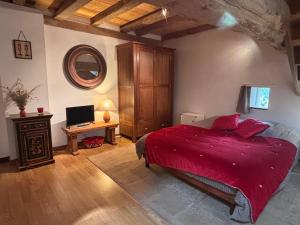 a bedroom with a red bed and a desk with a computer at Bruyère en Fleur in Clugnat