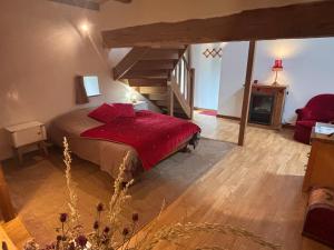 a bedroom with a bed with red pillows and a fireplace at Bruyère en Fleur in Clugnat +19 photos