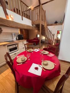 a kitchen with a table with a red table cloth at Bruyère en Fleur in Clugnat